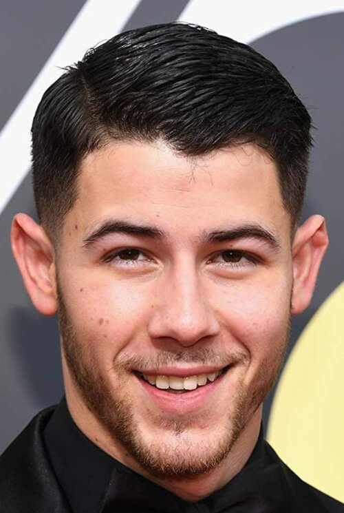 nick jonas slicked comb side textured hair.